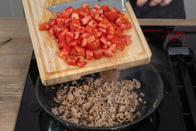 Tomatenwürfel zum Hackfleisch geben
