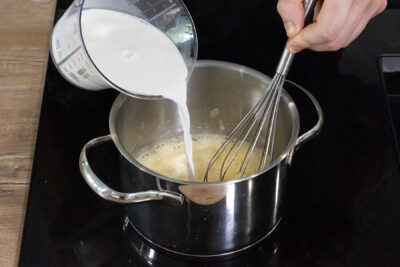 Milch zur Mehlschwitze gießen und Béchamelsauce herstellen