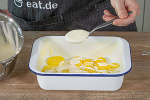Kartoffelscheiben und Sauce in die Auflaufform geben