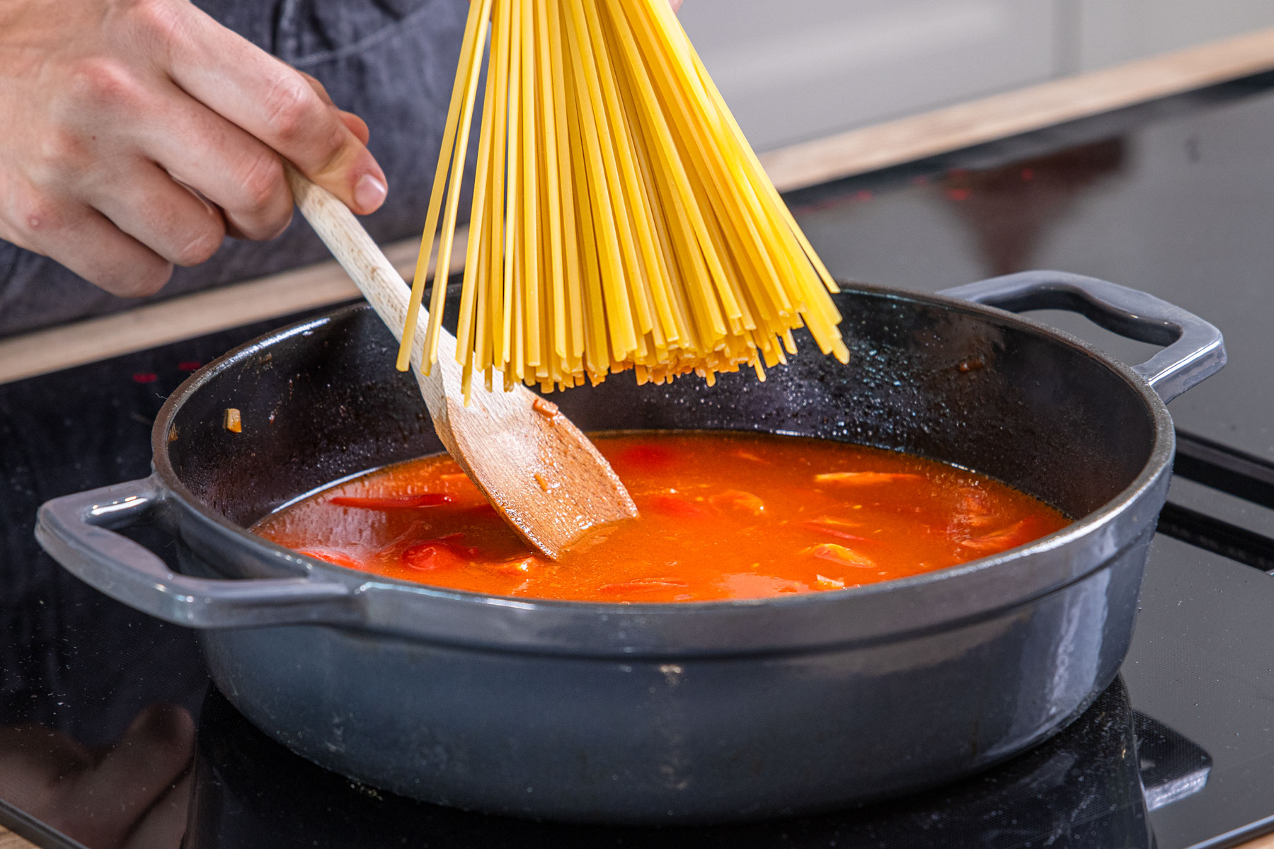 Spaghetti in den Topf geben
