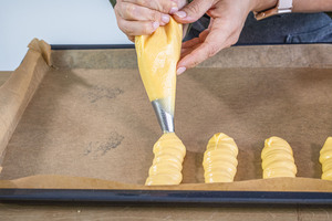 Eclairs auf das Backblech spritzen