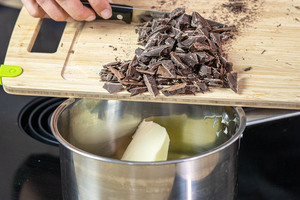 Kuvertüre zur Butter in den Topf geben