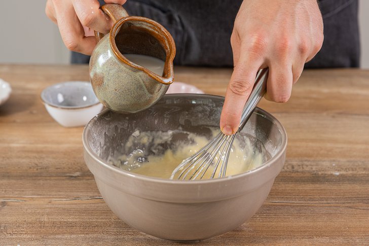 Milch in die Schüssel geben