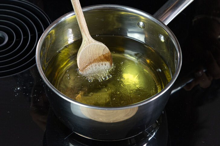 Öltemperatur mit einem Holzlöffel prüfen