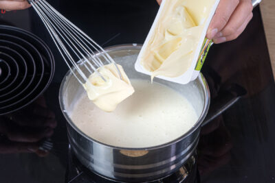 Schmelzkäse zur Béchamelsauce geben