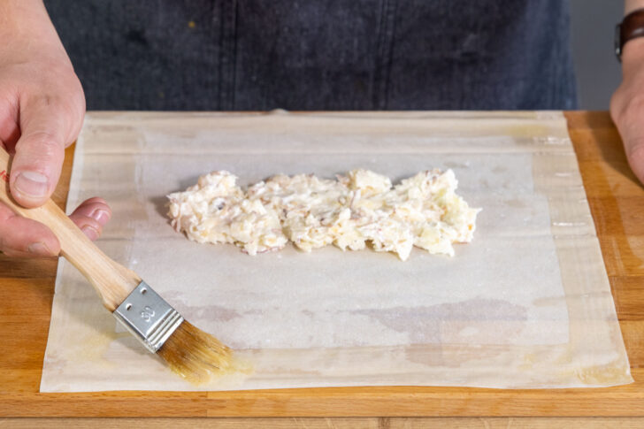 Ränder des Filoteig mit Butter bestreichen und Apfelmasse in die Mitte geben