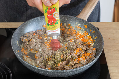 Tomatenmark und Kräuter der Provence dazugeben