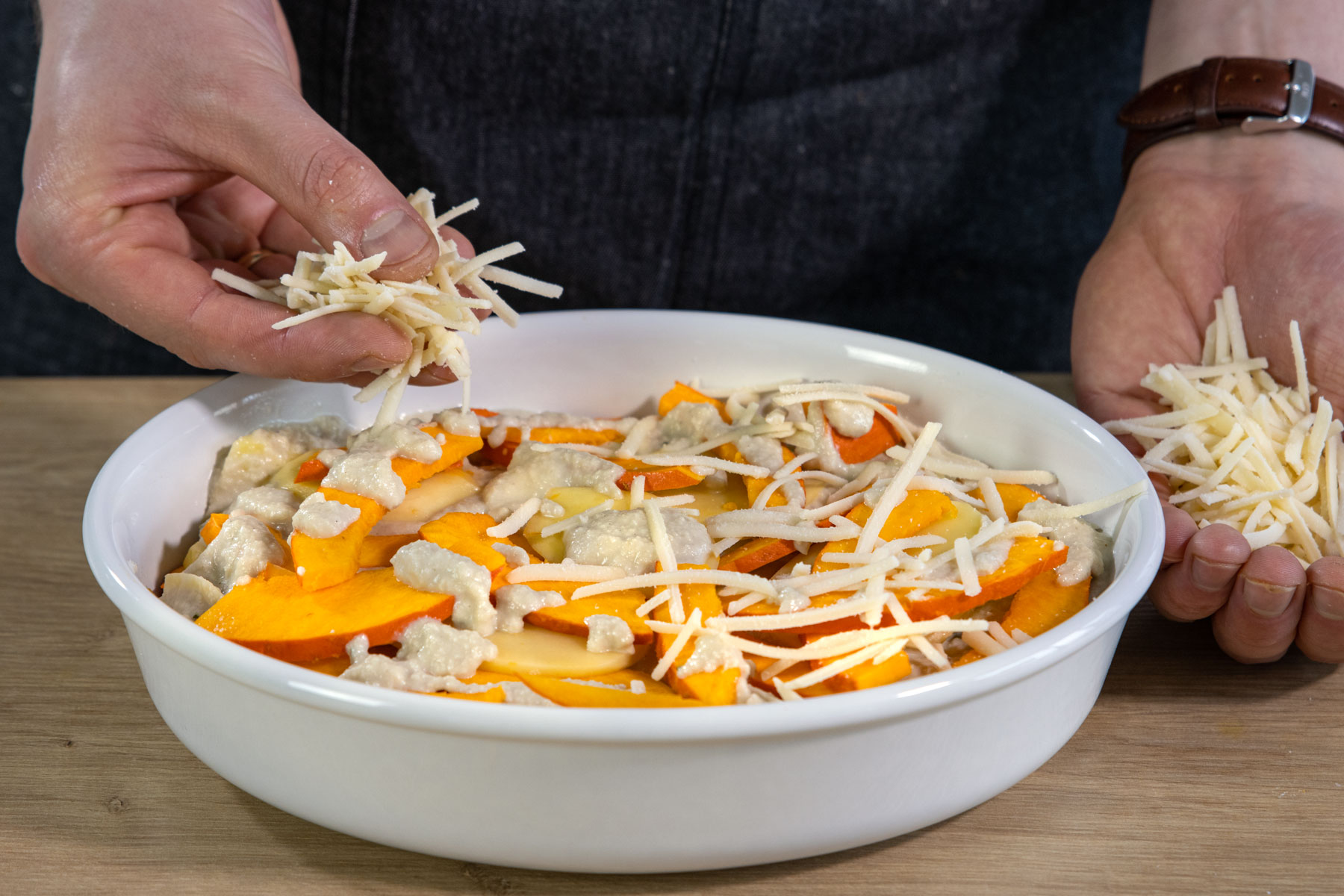 Käse über Auflauf streuen