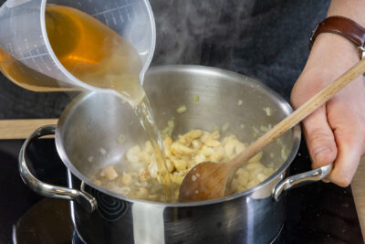 Gemüsebrühe zu den Cashews gießen