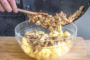 Gebratenes Gemüse und Käse zur Masse geben, für vegetarische Kohlrouladen mit Kartoffeln