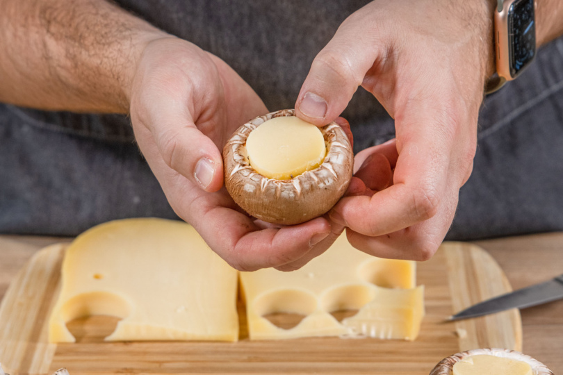 Käse in die Champignons drücken