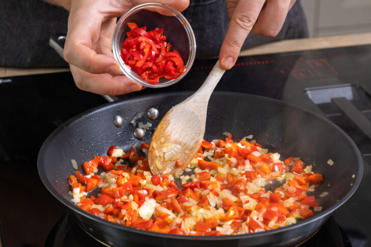 Chili zum Gemüse in der Pfanne geben