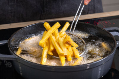 Pommes für Chili Cheese Fries im Topf frittieren