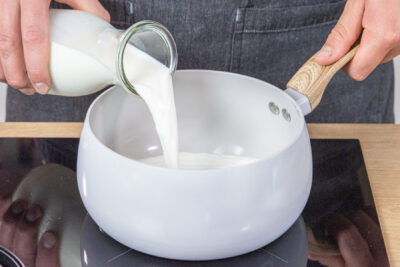 Milch in den Topf gießen