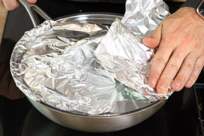 Wokdeckel mit der Alufolie abdichten