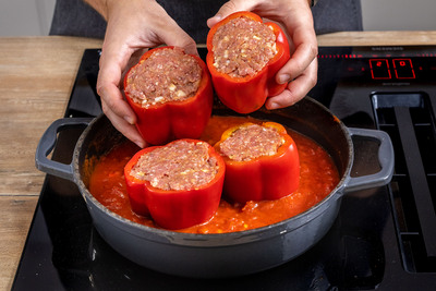 gefüllte Paprikas in die Pfanne zu der Tomatensauce geben