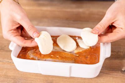 Mozzarella auf dem Hähnchenbrust-Auflauf verteilen