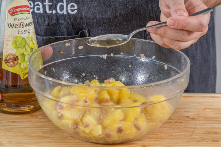 Essig zum warmen Kartoffelsalat geben