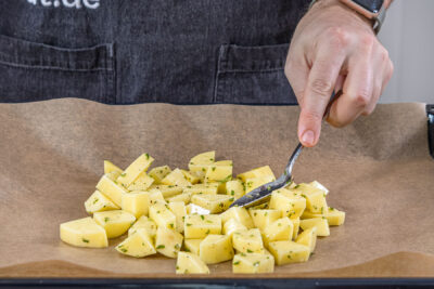 Kartoffeln auf das Blech geben