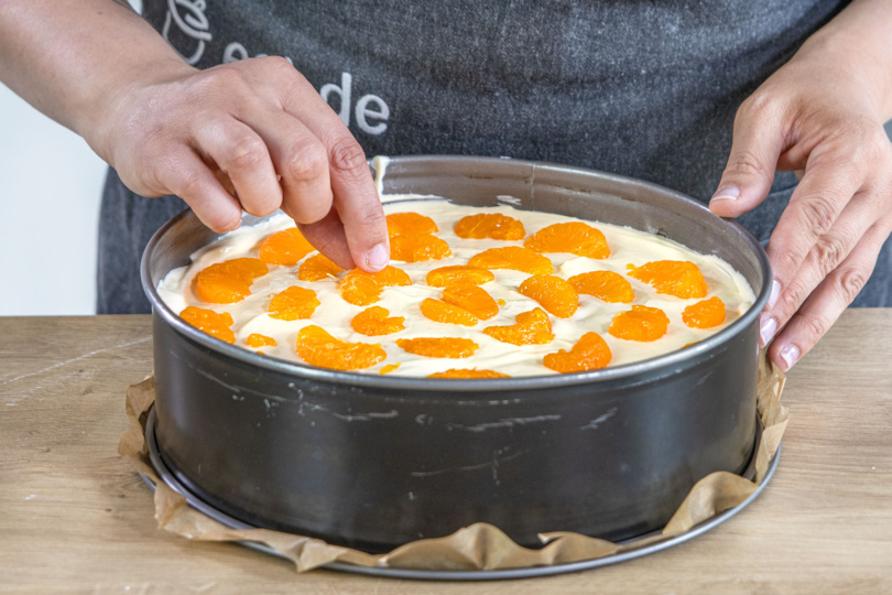 Mandarinen auf dem Quarkkuchen ohne Boden verteilen