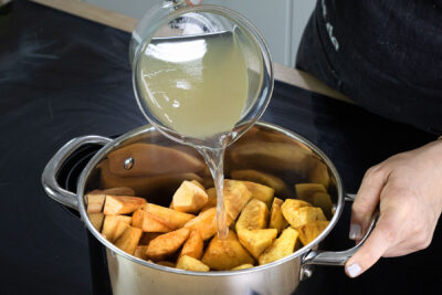 Quittenstücken mit Apfelsaft und Wasser kochen