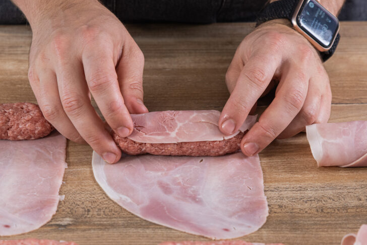 Hackfleisch mit dem Schinken einrollen