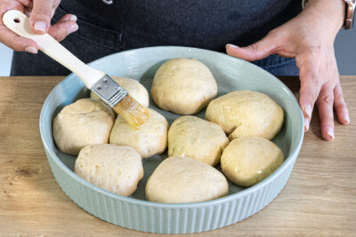 Buchteln mit geschmolzener Butter einstreichen