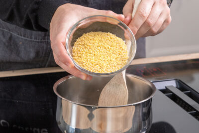 Bulgur für Bulgursalat in den Topf geben
