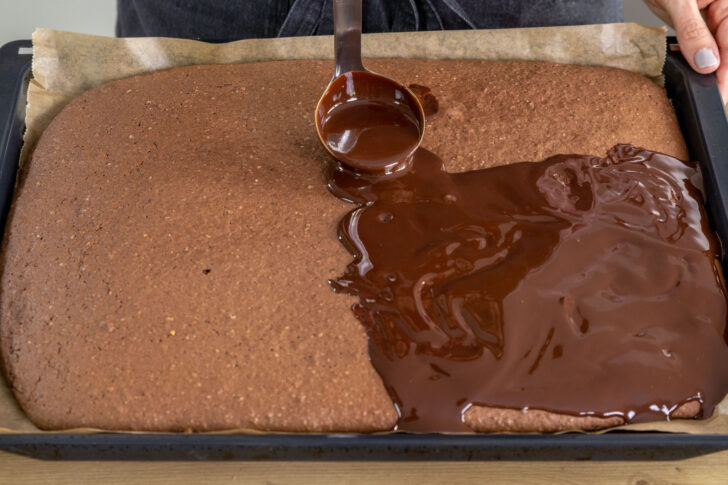 Glasur auf dem abgekühlten Gewürzkuchen vom Blech verteilen