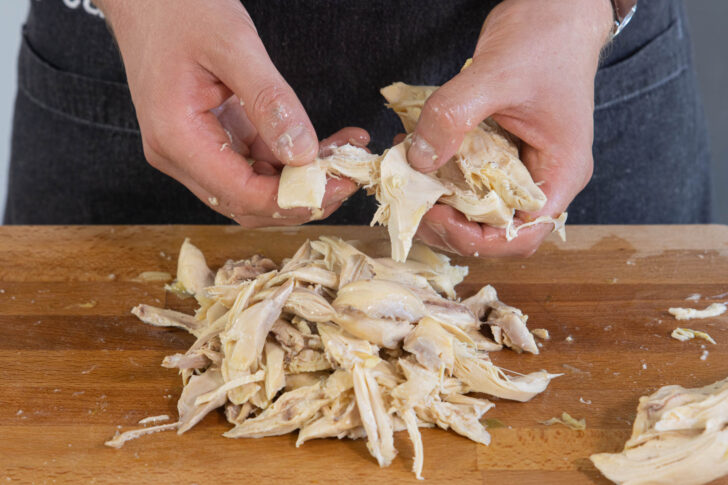Fleisch für die Hühnersuppe zupfen