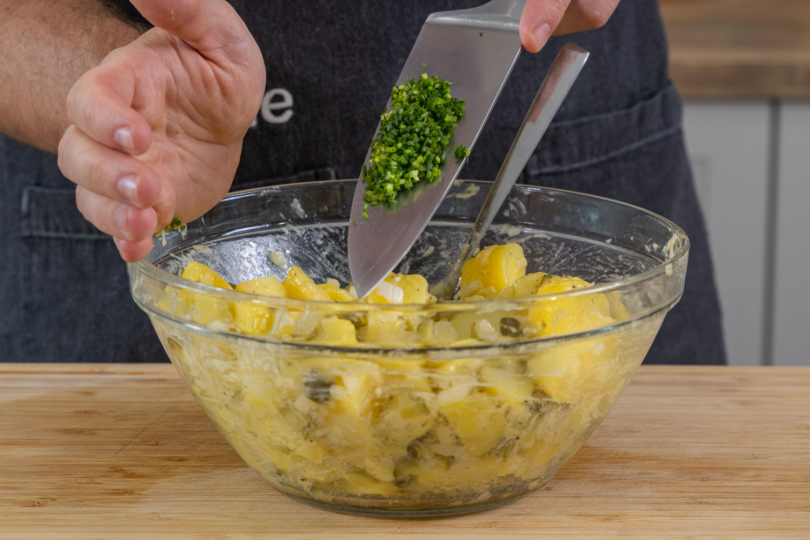 Kartoffelsalat mit Schnittlauch verrühren