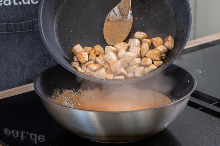 Lachswürfel zur Sauce geben