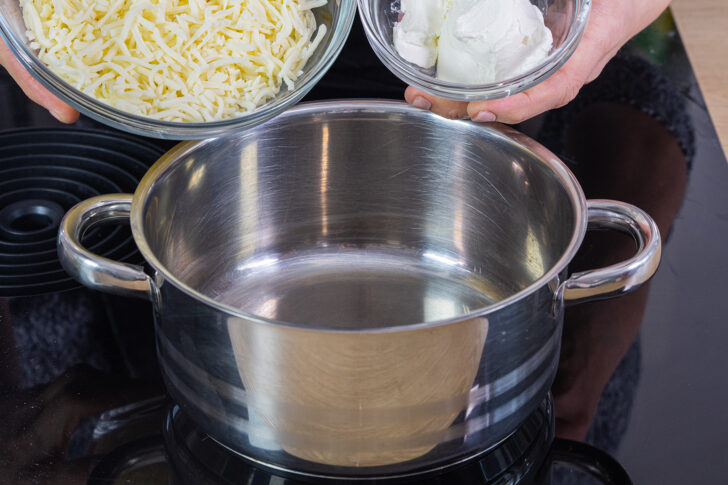 geriebenen Mozzarella und Frischkäse in einen Topf geben