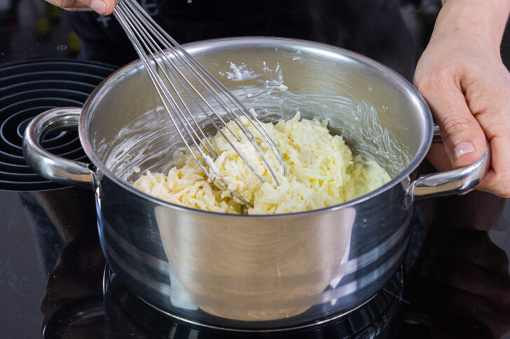 geriebenen Mozzarella und Frischkäse im Topf schmelzen lassen