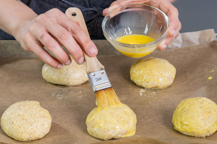 Teig für Burger Buns mit Eigelb-Milch-Mischung bestreichen