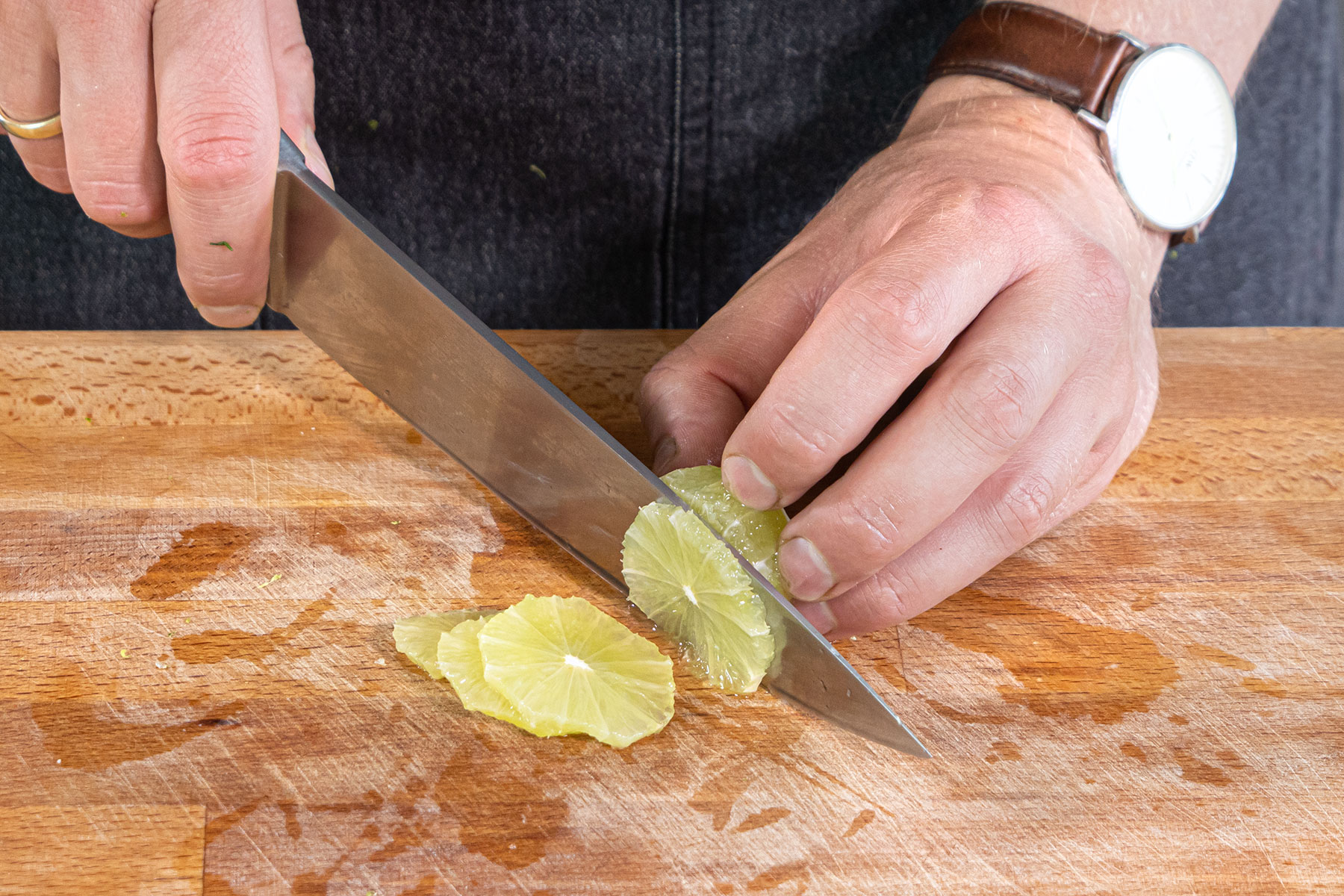 Limette schälen und in Scheiben schneiden