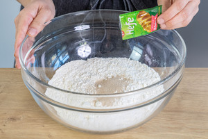 Mehl mit der Trockenhefe für die Neujahrsbrezel in eine Schüssel geben