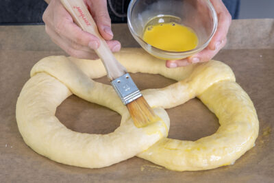 Brezel mit Ei-Milch-Mischung bepinseln