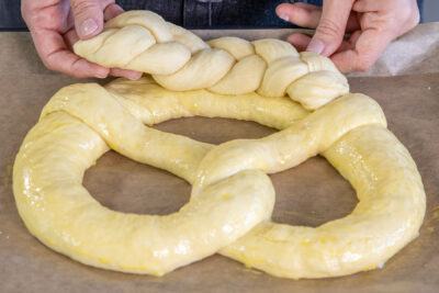 geflochtenen Zopf auf den unteren Bogen der Brezel legen