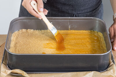 Marmelade auf den Mürbeteigboden streichen