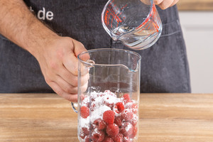 Wasser zu den Himbeeren geben