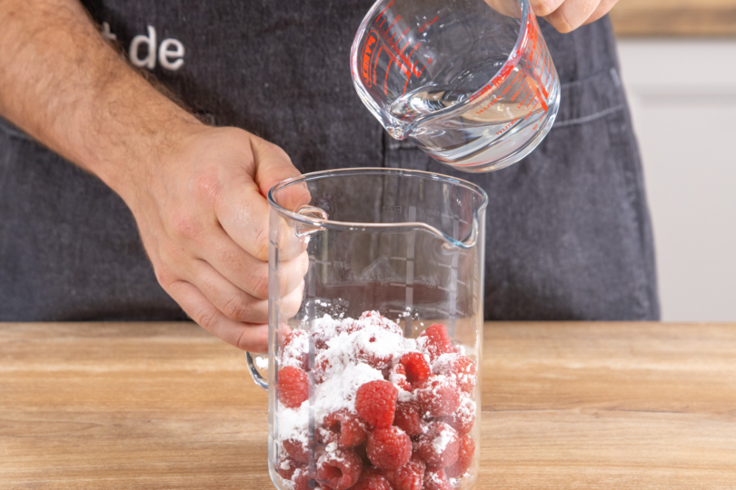 Wasser zu den Himbeeren geben
