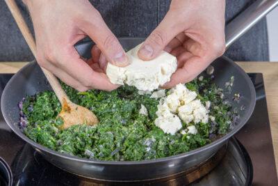 Feta zum Spinat bröseln