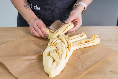 Den Topfenstriezel zu einem Zopf flechten