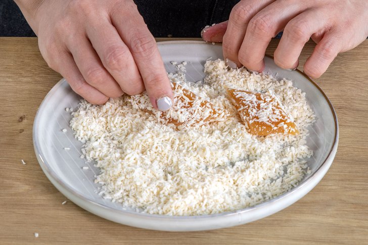 Quittenbrotstücke in Kokosraspel wälzen