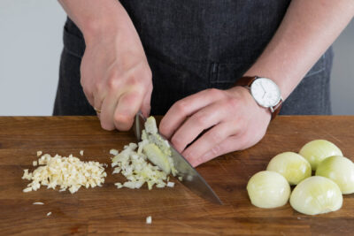 Zwiebeln und Knoblauch klein schneiden
