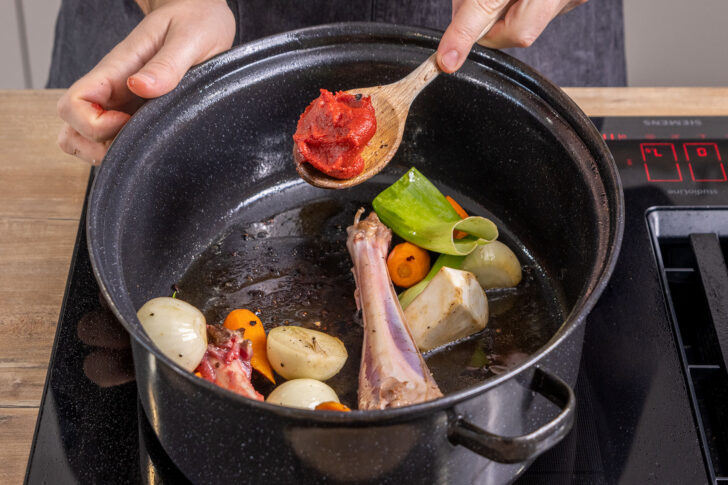 Tomatenmark zum Gemüse geben