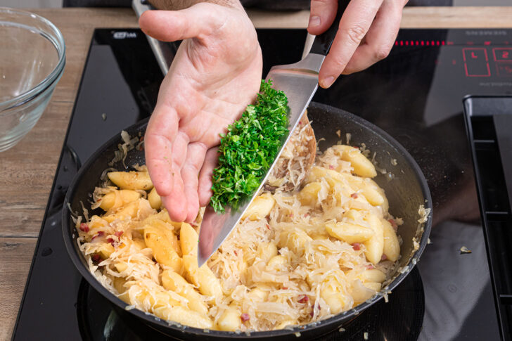 Petersilie zu den Schupfnudeln mit Sauerkraut geben