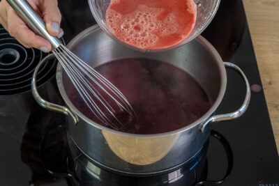 angerühretes Puddingpulver zum Kirschsaft gießen