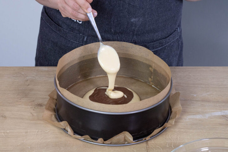 Für den Zebrakuchen abwechseln hellen und dunklen Teig einfüllen